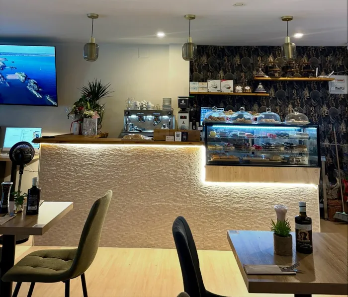 Barra iluminada con cafetera y vitrina de pasteles